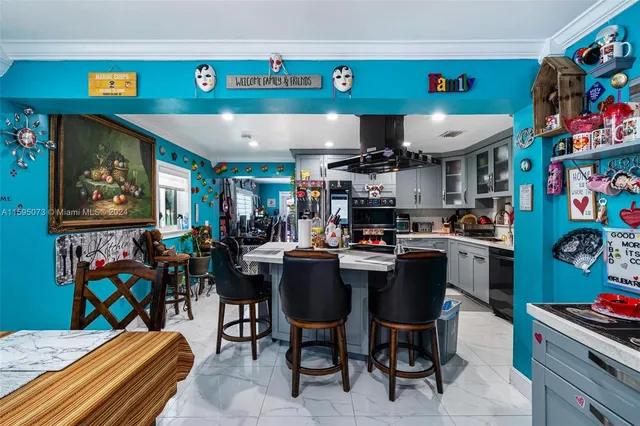 a room with stainless steel appliances lots of furniture and clutter