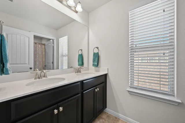 a bathroom with a double vanity sink and a mirror