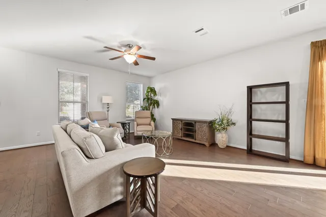 a living room with furniture and a wooden floor