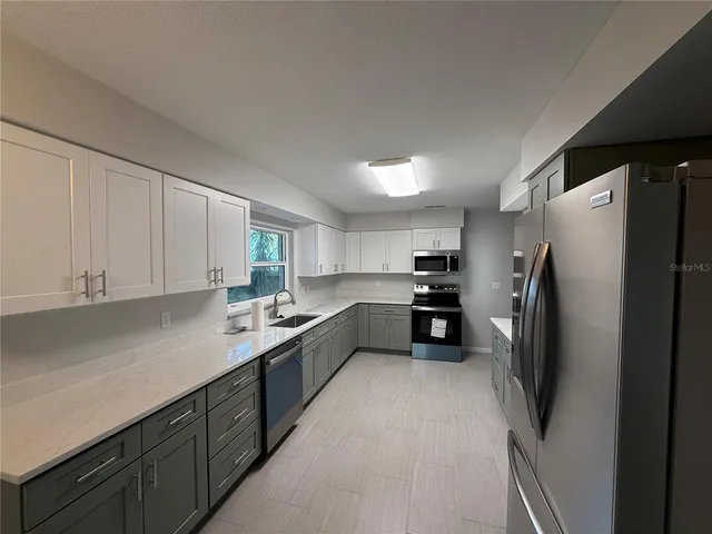 a kitchen with a refrigerator sink and cabinets