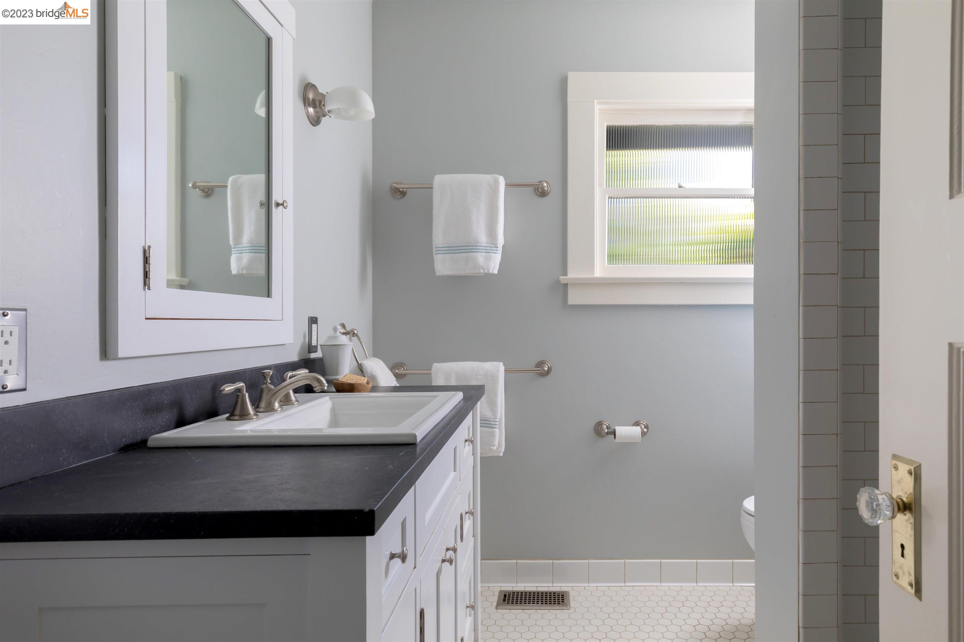 911 Tulare Avenue Berkeley, CA 94707 - Photo 15 of 21 a bathroom with a granite countertop sink a mirror and a bathtub