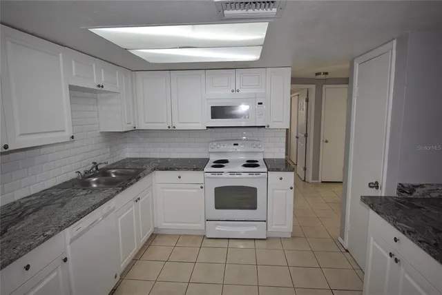 a kitchen with a stove sink and cabinets