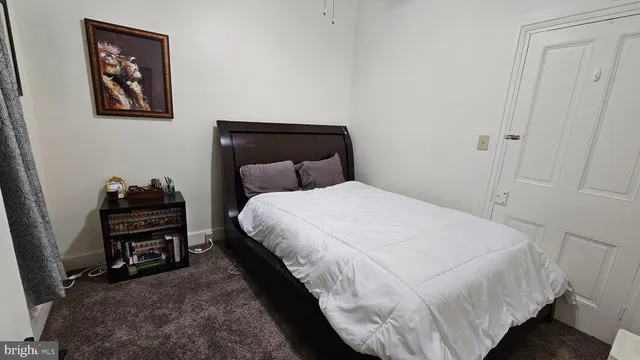 a bedroom with a bed and a wooden floor