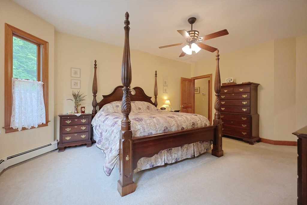 70 Azalea Way Hanson, MA 02341 - Photo 24 of 42 a bedroom with a bed and a chandelier