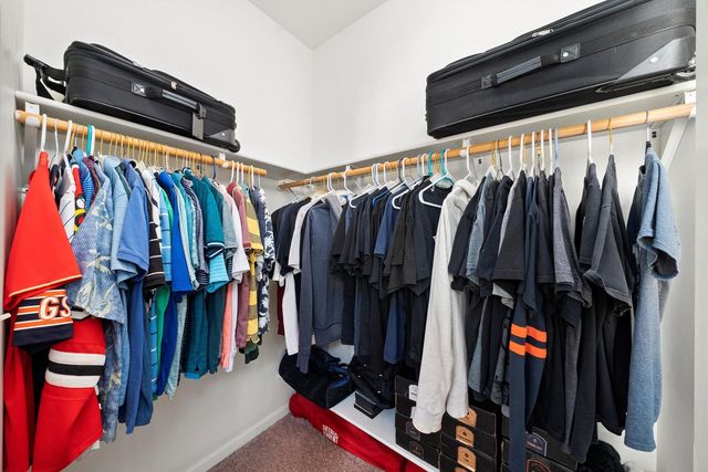 a view of walk in closet with clothes and shoes