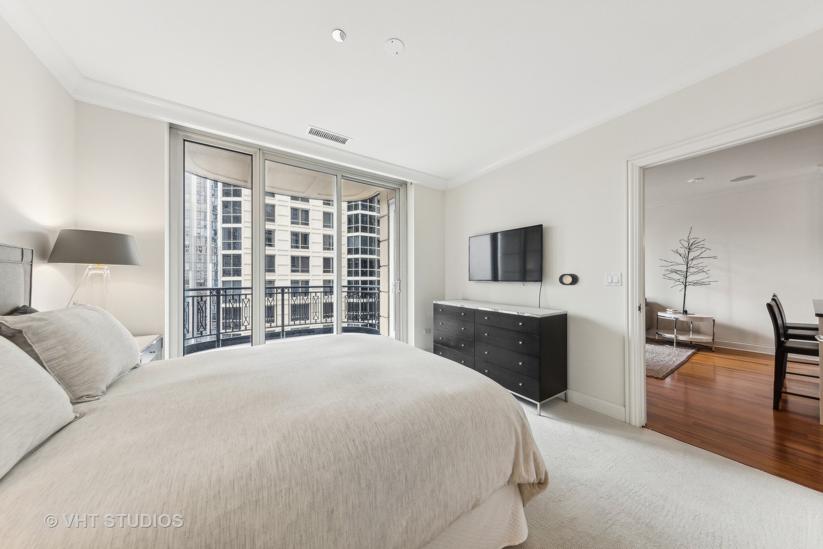10 East Delaware Place, Unit 19C Chicago, IL 60611 - Photo 11 of 25 a spacious bedroom with a large bed and a flat tv screen on dresser