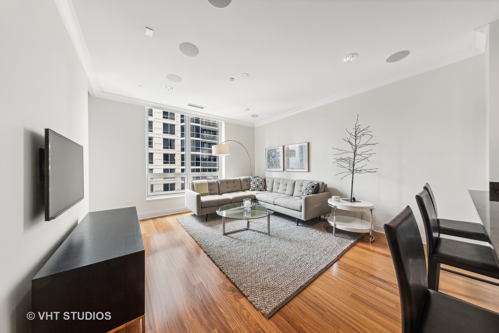 10 East Delaware Place, Unit 19C Chicago, IL 60611 - Photo 5 of 25 a living room with furniture and a flat screen tv