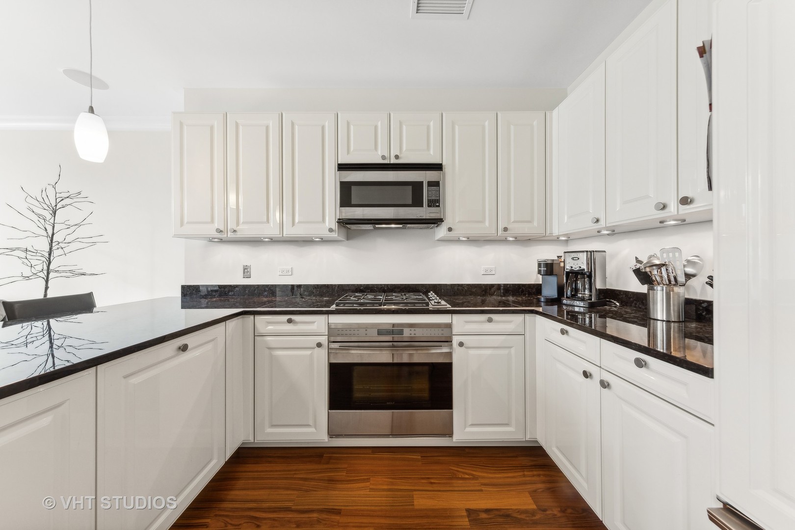 10 East Delaware Place, Unit 19C Chicago, IL 60611 - Photo 10 of 25 a kitchen with granite countertop a stove top oven sink and cabinets