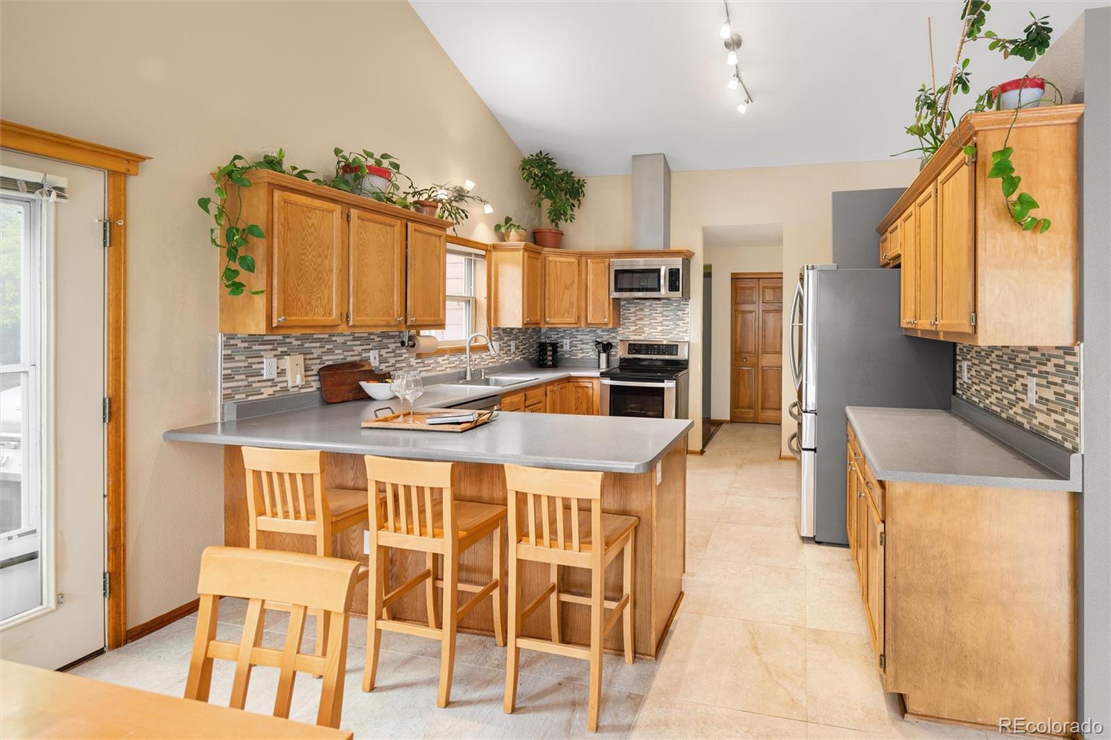 11163 Conifer Mountain Road Conifer, CO 80433 - Photo 18 of 46 a kitchen with stainless steel appliances kitchen island granite countertop a refrigerator and a stove top oven
