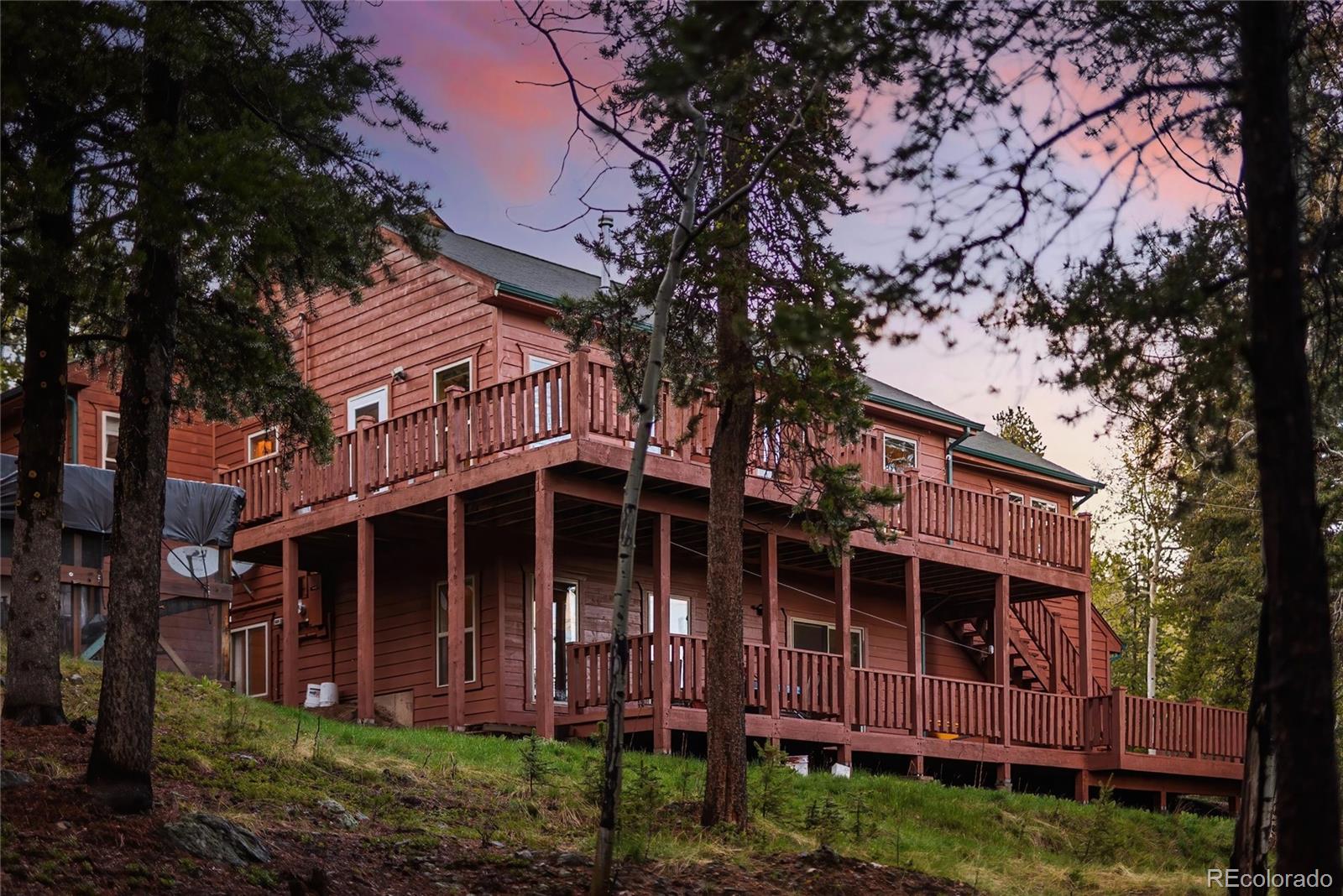 11163 Conifer Mountain Road Conifer, CO 80433 - Photo 2 of 46 a front view of a house with a garden