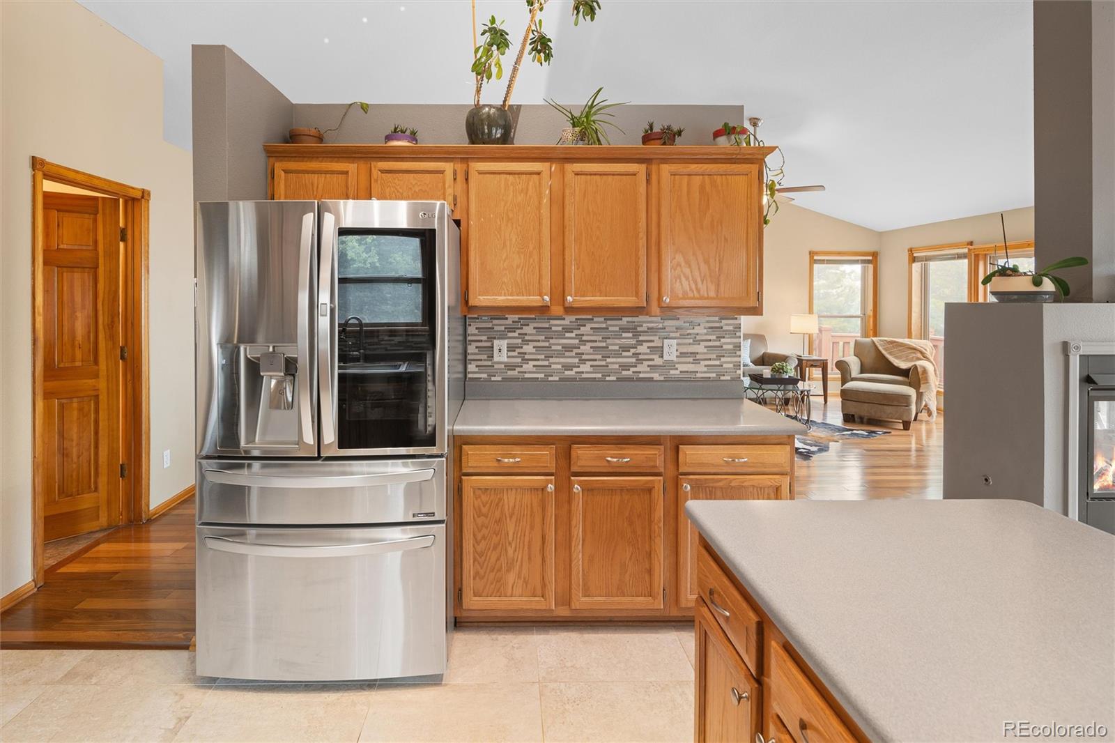11163 Conifer Mountain Road Conifer, CO 80433 - Photo 22 of 46 a kitchen with stainless steel appliances kitchen island wooden cabinets and granite counter tops