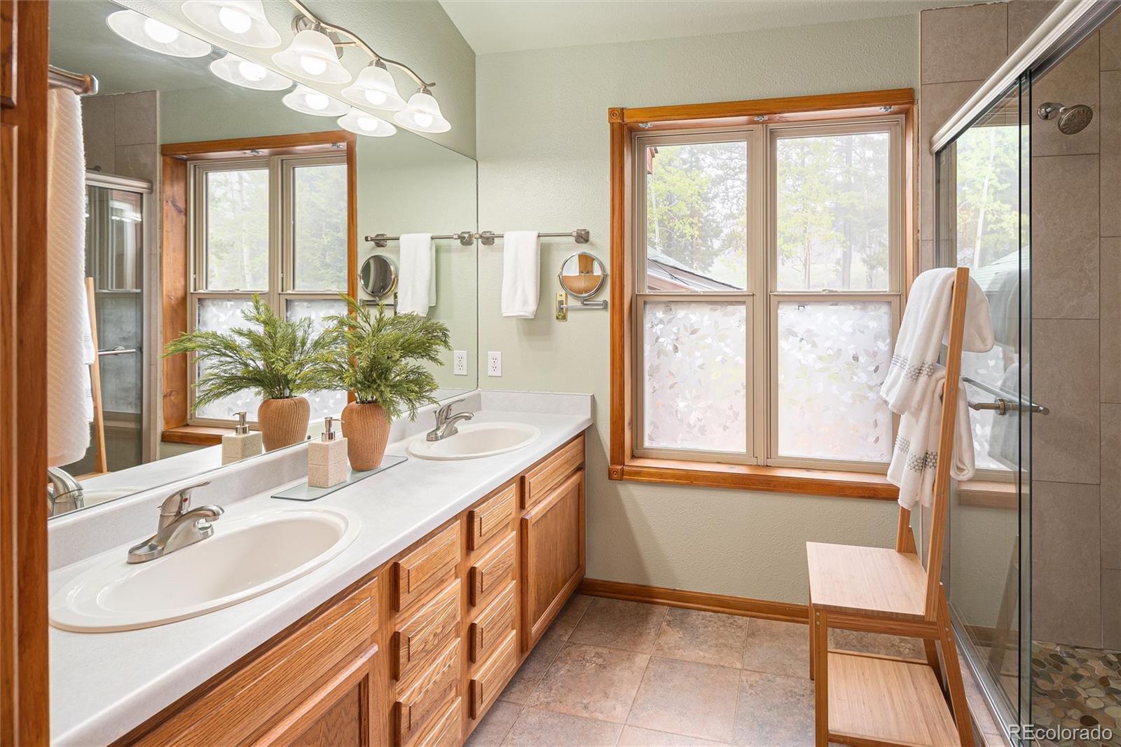 11163 Conifer Mountain Road Conifer, CO 80433 - Photo 25 of 46 a bathroom with a double vanity sink and a mirror