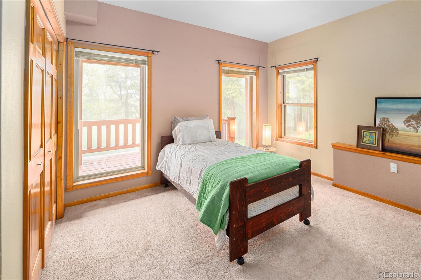 11163 Conifer Mountain Road Conifer, CO 80433 - Photo 28 of 46 a bedroom with a bed a dresser next to a window