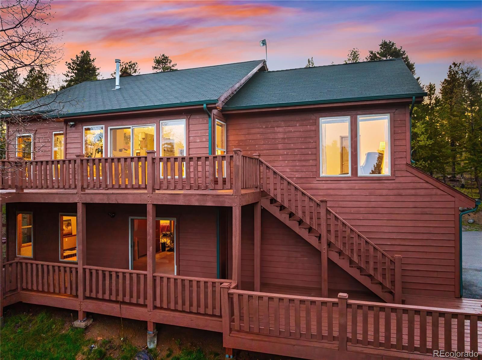 11163 Conifer Mountain Road Conifer, CO 80433 - Photo 33 of 46 a view of a house with wooden deck front of house
