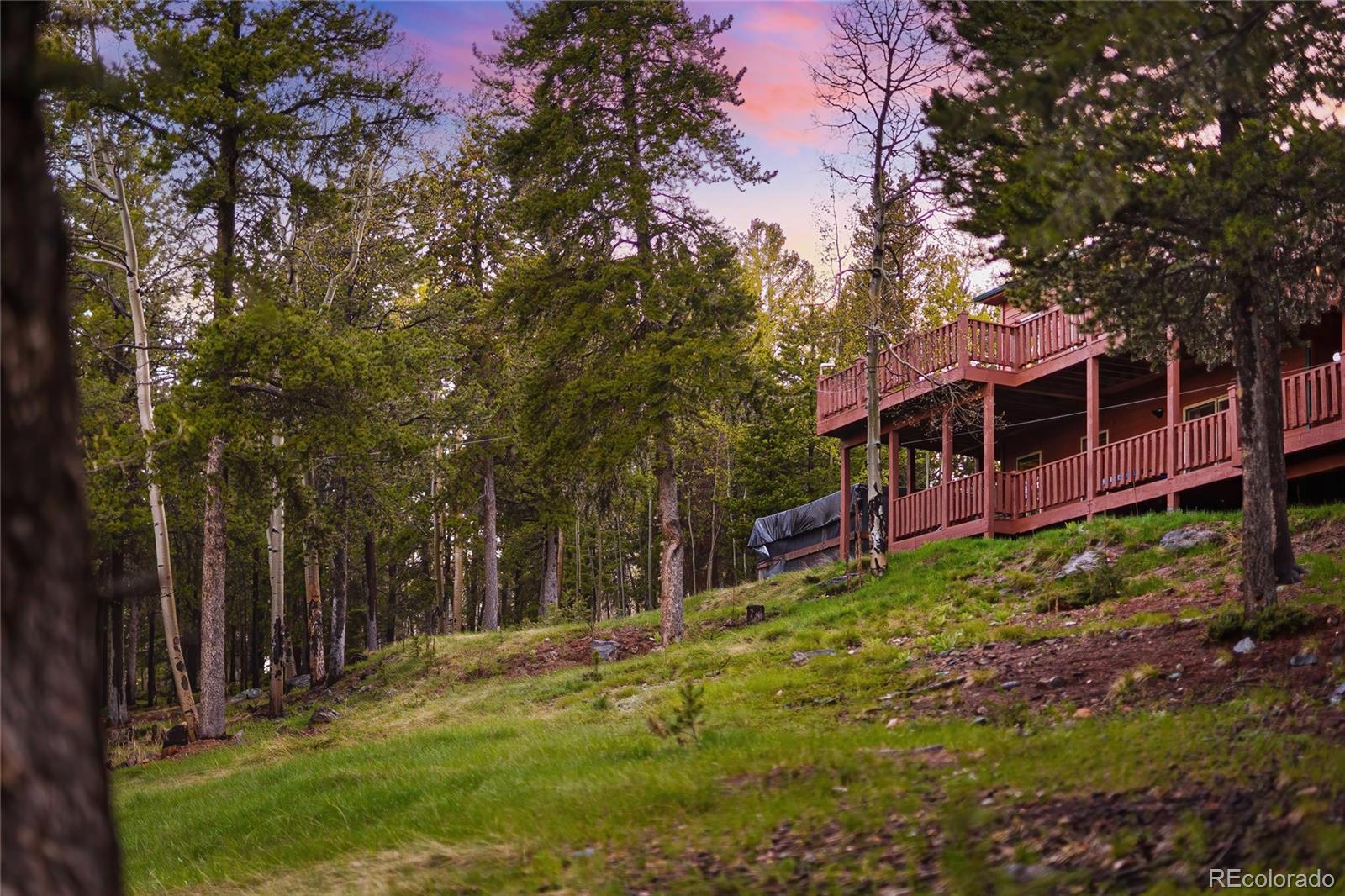 11163 Conifer Mountain Road Conifer, CO 80433 - Photo 39 of 46 a view of a backyard with wooden fence and large trees