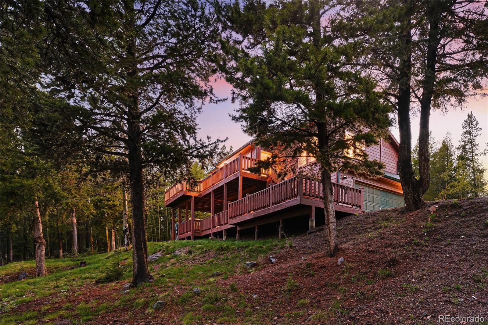 11163 Conifer Mountain Road Conifer, CO 80433 - Photo 40 of 46 a large tree in front of a house