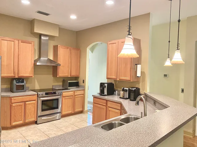 a kitchen with stainless steel appliances granite countertop a sink a stove and a refrigerator