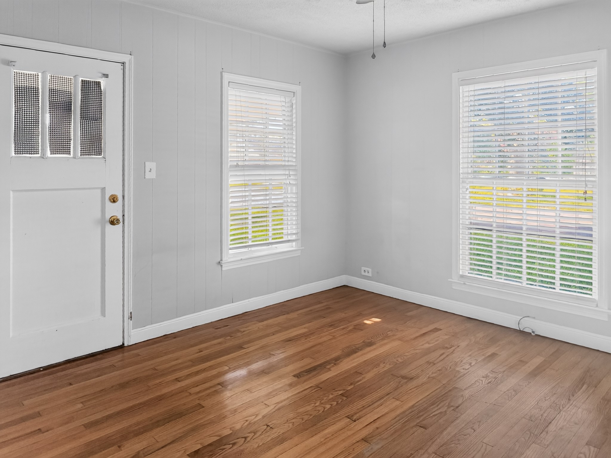 2313 Avenue L Rosenberg, TX 77471 - Photo 17 of 31 Bright bedroom with hardwood floors, large windows, and abundant natural light creating a warm, inviting atmosphere.