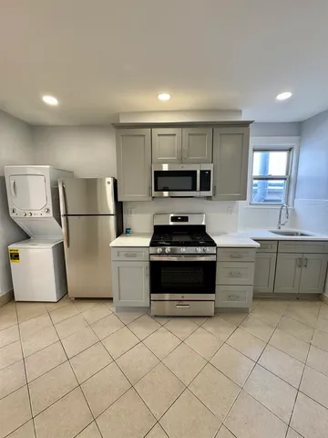 a kitchen with stainless steel appliances a stove a sink and a refrigerator