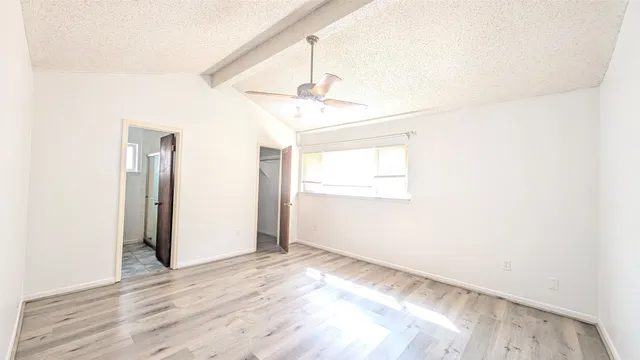 a spacious bathroom with a granite countertop sink a toilet and a mirror