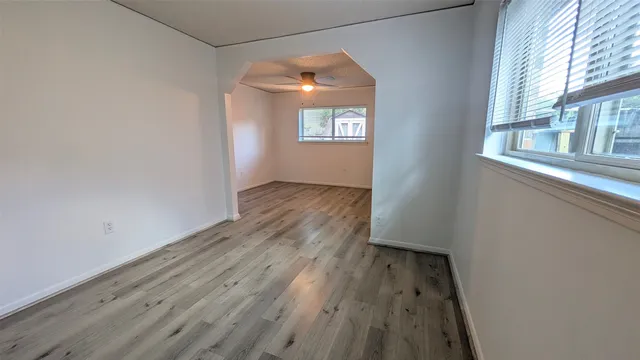 a view of room with wooden floor and fan