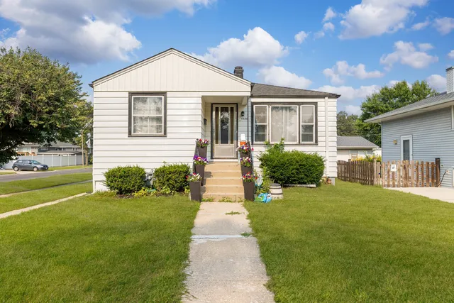 a front view of a house with a yard and potted plants