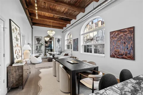 a kitchen with stainless steel appliances granite countertop a table chairs stove and refrigerator