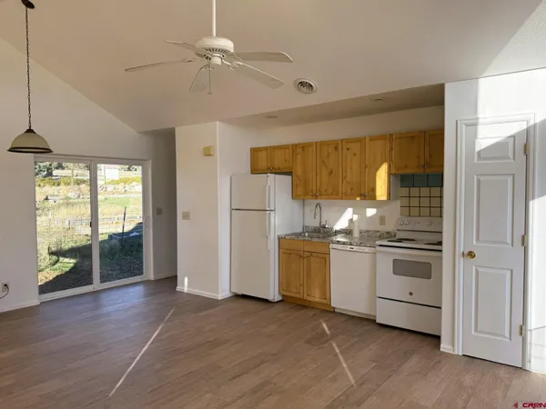 a kitchen with stainless steel appliances granite countertop a stove a refrigerator and a sink with wooden floor