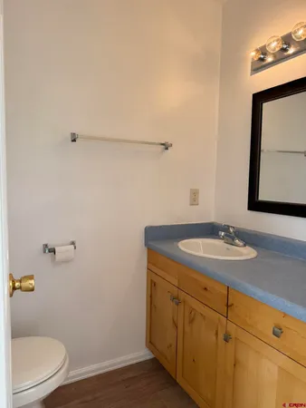 a bathroom with a granite countertop sink a toilet and mirror