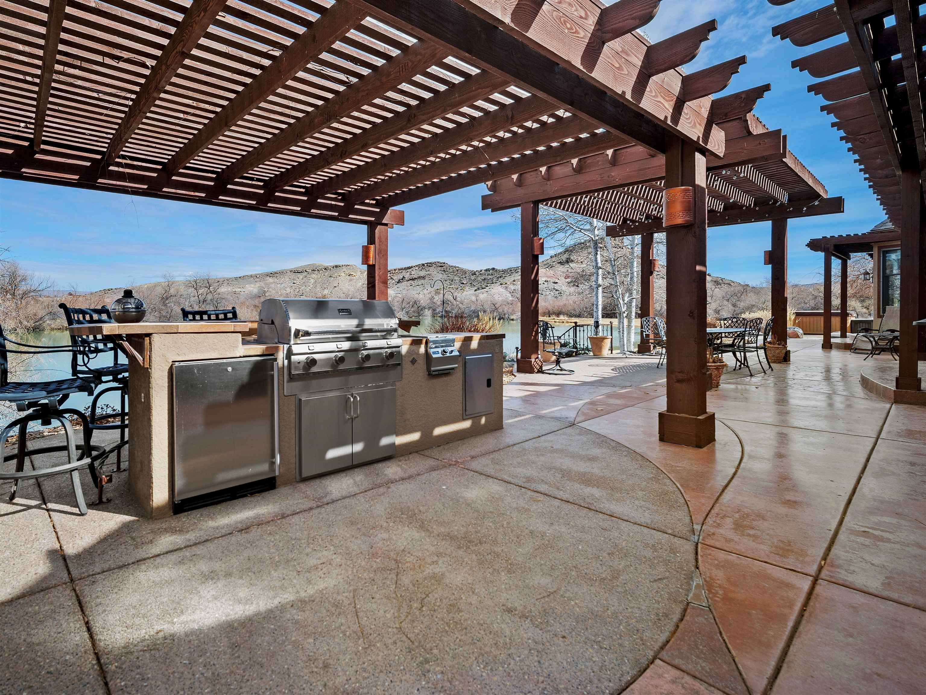 2111 Desert Hill Road Grand Junction, CO 81507 - Photo 27 of 34 a view of a patio with a table and chairs under a large umbrella with a barbeque grill