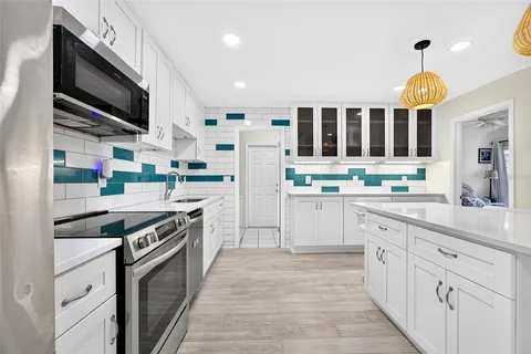 a kitchen with stainless steel appliances kitchen island granite countertop a stove and a sink