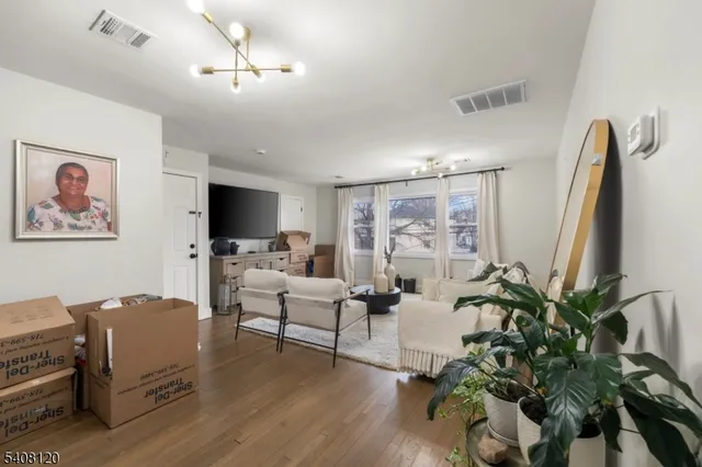 a living room with furniture potted plant and a flat screen tv