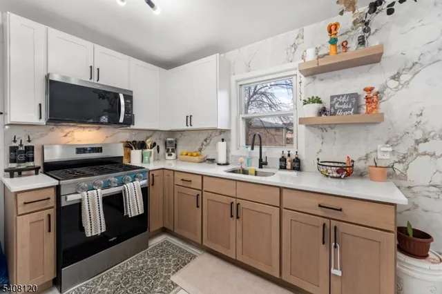 a kitchen with stainless steel appliances granite countertop a sink and a stove