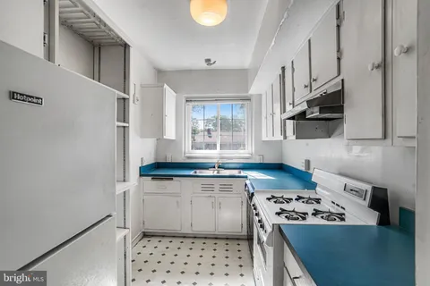 a kitchen with granite countertop a stove a sink and a refrigerator