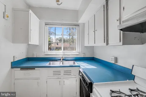 a kitchen with a sink cabinets and a window