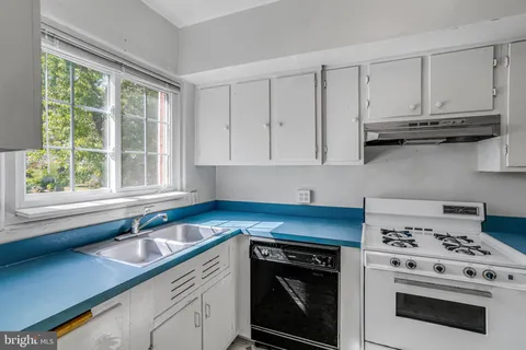 a kitchen with white cabinets and appliances