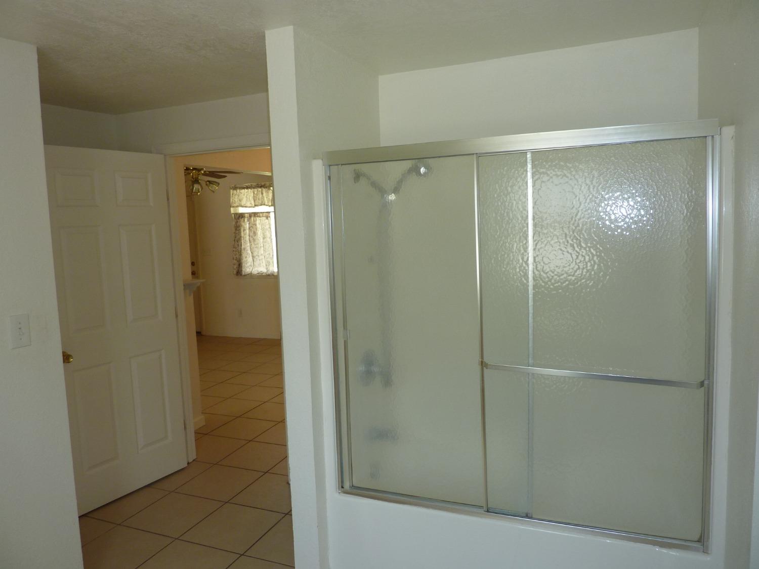 2629 East Richert Avenue Fresno, CA 93726 - Photo 14 of 32 a bathroom with a glass shower door