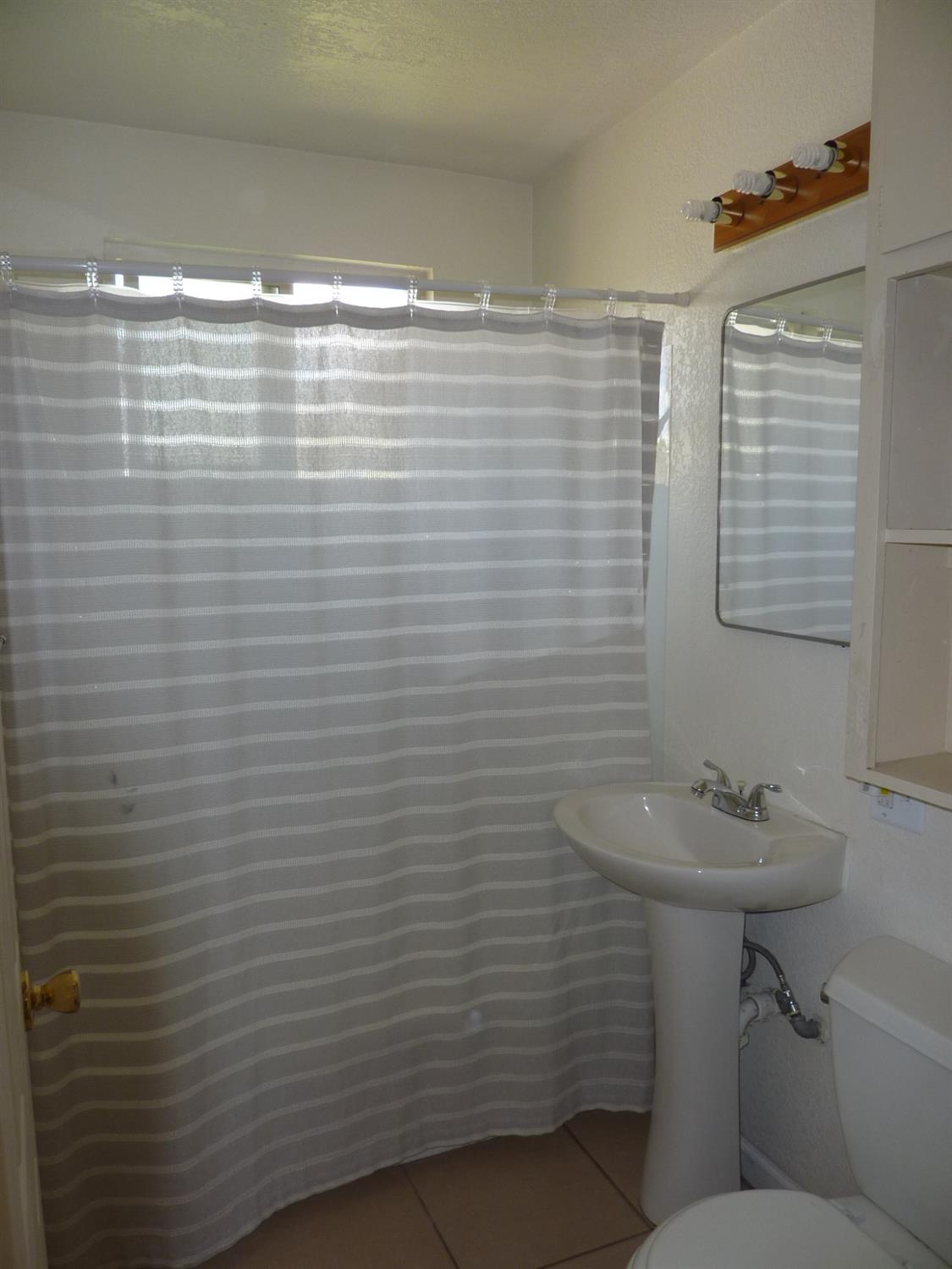 2629 East Richert Avenue Fresno, CA 93726 - Photo 16 of 32 a bathroom with a sink a toilet and shower