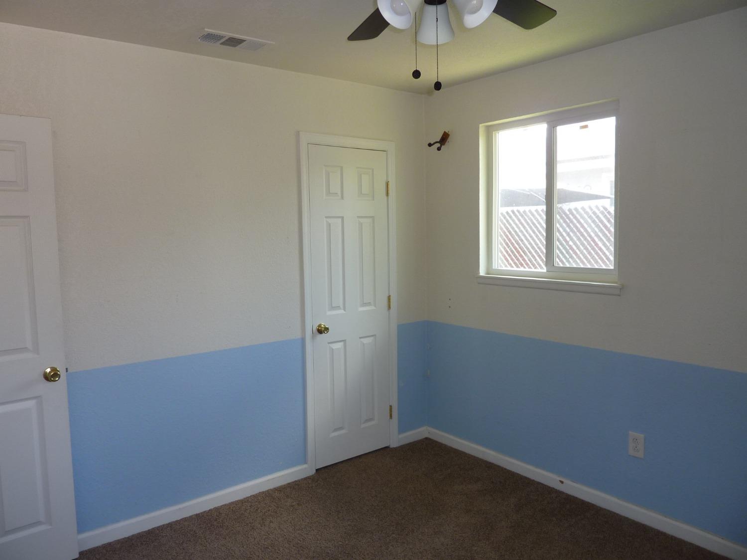 2629 East Richert Avenue Fresno, CA 93726 - Photo 17 of 32 an empty room with a window and a fan