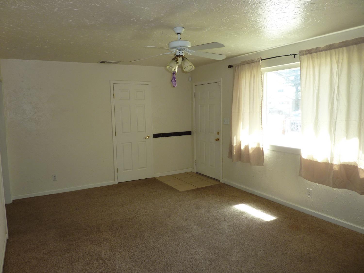 2629 East Richert Avenue Fresno, CA 93726 - Photo 4 of 32 wooden floor in an empty room with a window