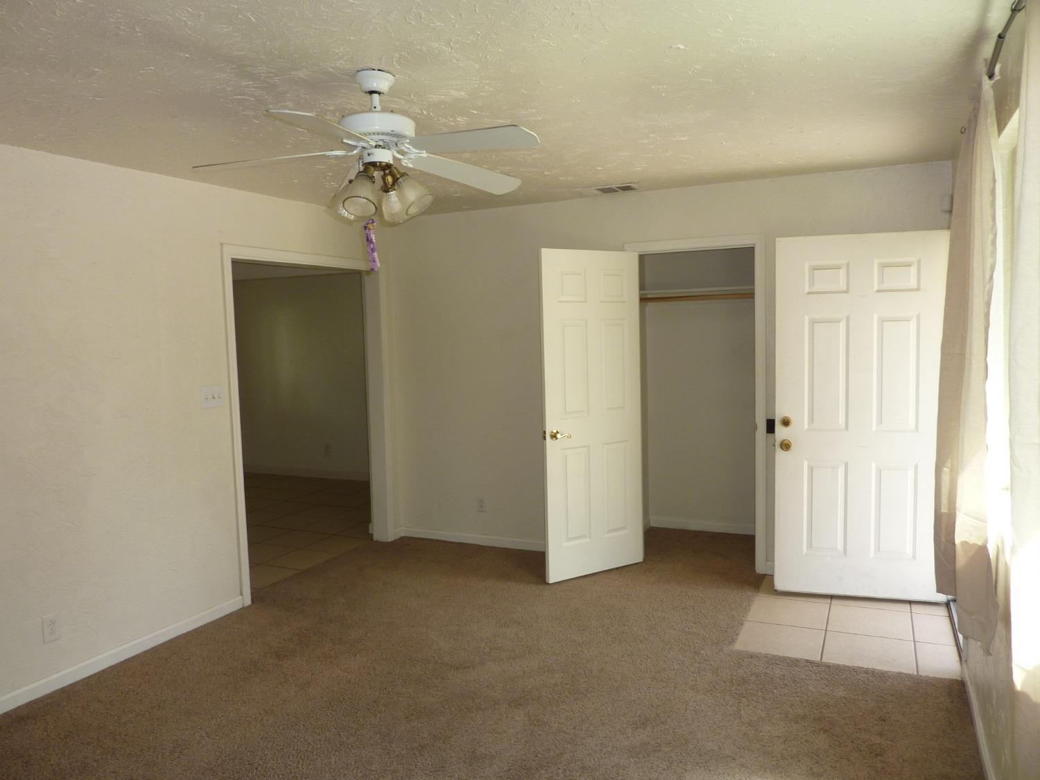 2629 East Richert Avenue Fresno, CA 93726 - Photo 6 of 32 wooden floor in an empty room with a window