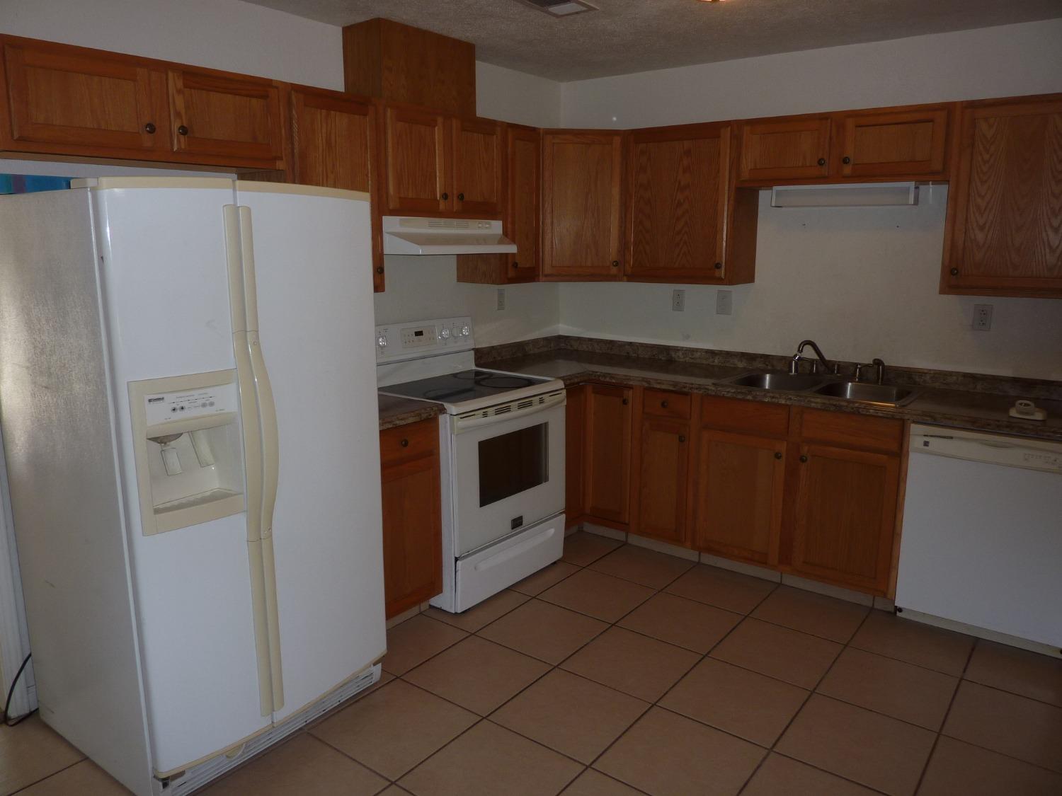 2629 East Richert Avenue Fresno, CA 93726 - Photo 8 of 32 a kitchen with a sink a stove and refrigerator
