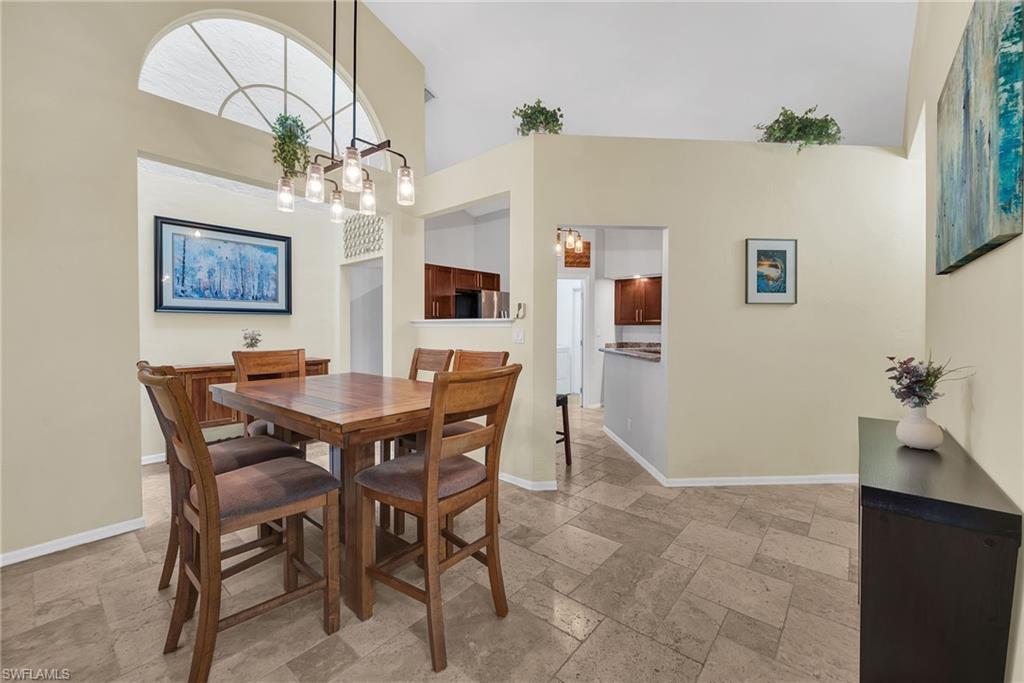 181 Napa Ridge Road East, Unit 35 Naples, FL 34119 - Photo 8 of 21 Open concept dining area with high ceilings, featuring a contemporary multi-bulb linear pendant light fixture