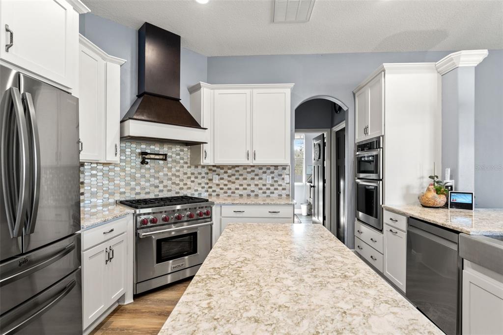 12277 Eskimo Curlew Road Weeki Wachee, FL 34614 - Photo 12 of 84 a kitchen with stainless steel appliances a stove a refrigerator and a sink