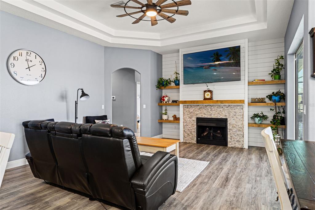 12277 Eskimo Curlew Road Weeki Wachee, FL 34614 - Photo 18 of 84 a living room with furniture a flat screen tv and a fireplace