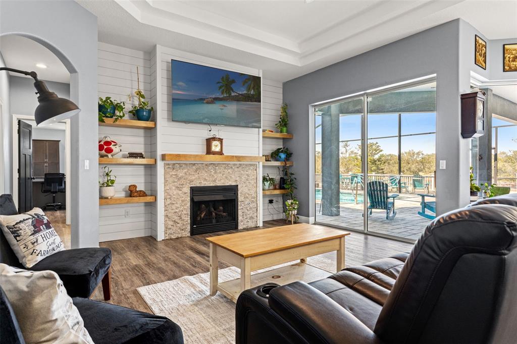 12277 Eskimo Curlew Road Weeki Wachee, FL 34614 - Photo 19 of 84 a living room with furniture large window and a fireplace