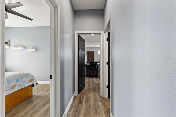 a view of a roof deck with dining table and chairs under an umbrella with wooden floor