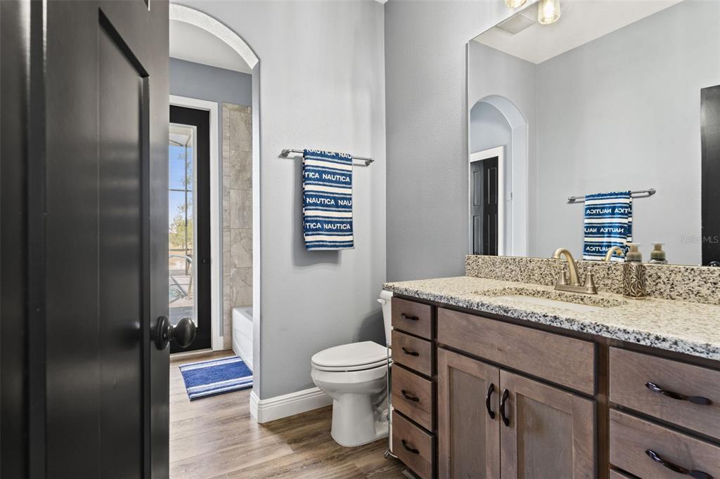 12277 Eskimo Curlew Road Weeki Wachee, FL 34614 - Photo 44 of 84 a bathroom with a granite countertop sink toilet and mirror