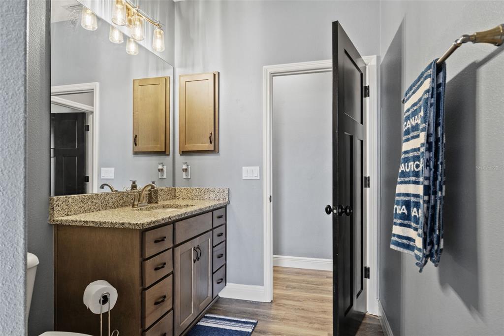 12277 Eskimo Curlew Road Weeki Wachee, FL 34614 - Photo 45 of 84 a bathroom with a granite countertop sink a mirror and shower