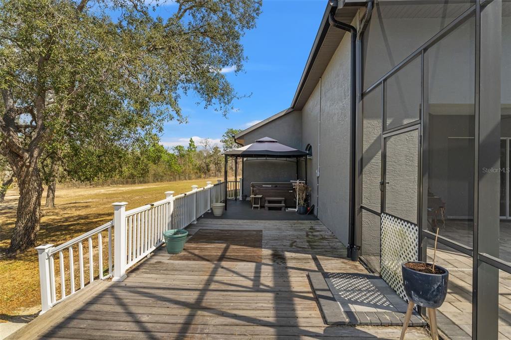 12277 Eskimo Curlew Road Weeki Wachee, FL 34614 - Photo 66 of 84 a view of a balcony with wooden floor and outdoor seating
